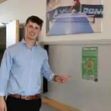 Man pointing out a poster with Meta Learn on a wall