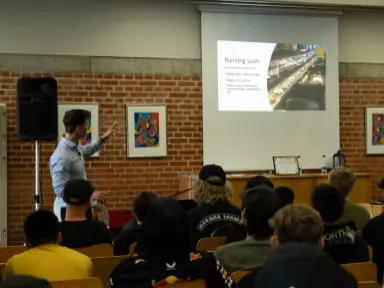 Man talking about slides containing info about Meta Learn