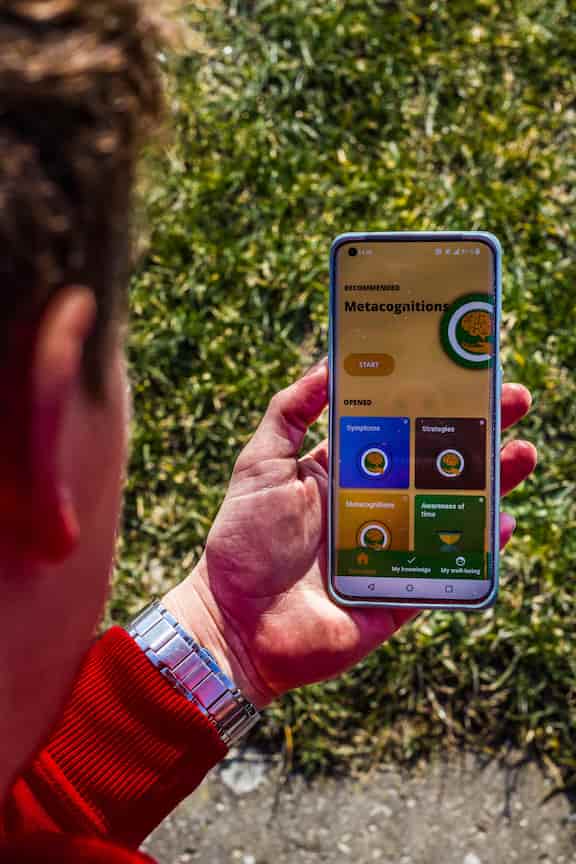 En mand holder en telefon med Meta Learn appen.